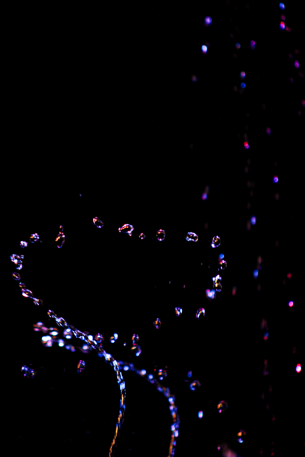 Backlit water splash glowing red and blue