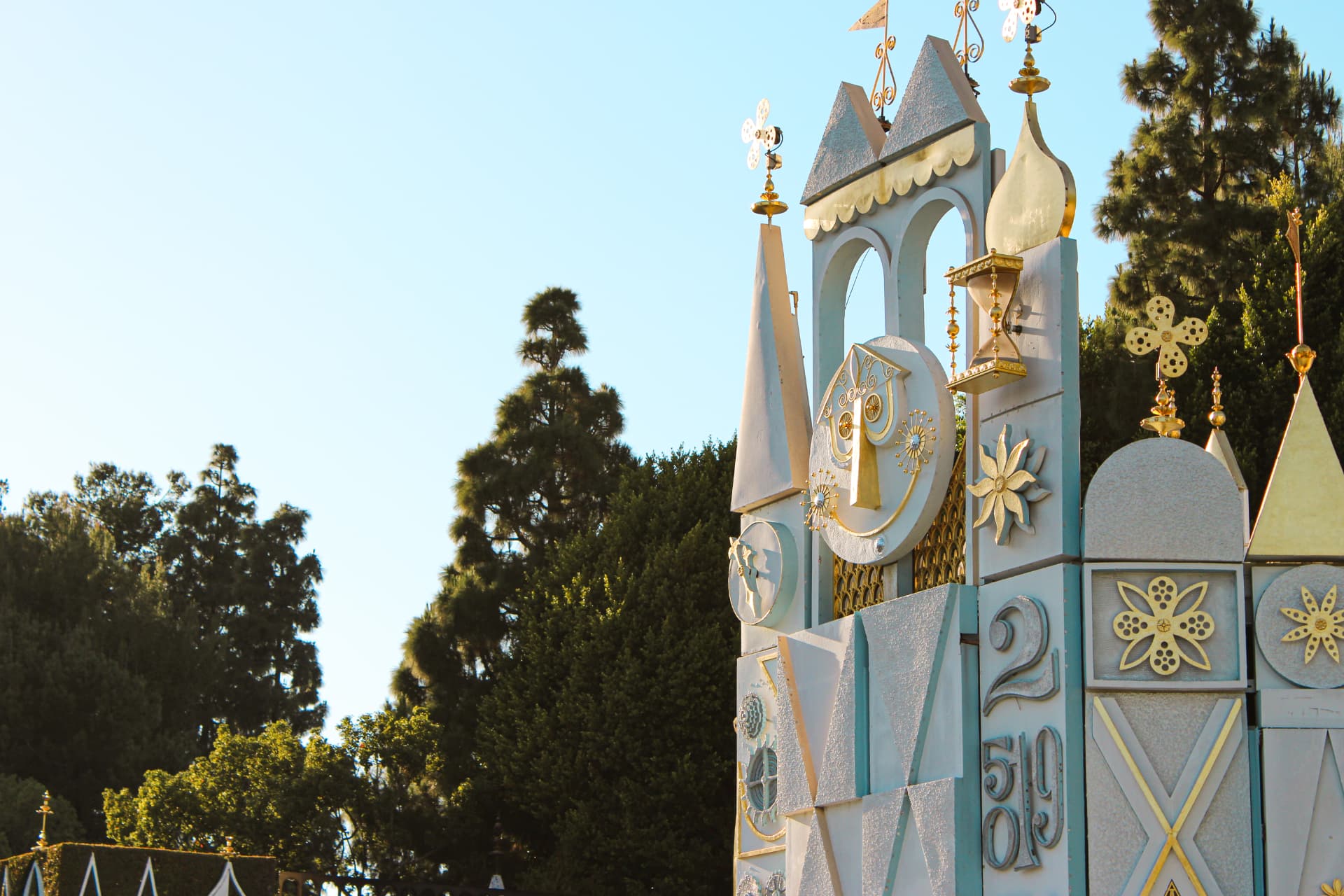 White-and-gold storybook facade against trees and a clear sky